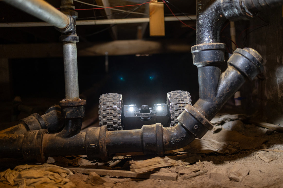 Crawlspace inspection robot examining plumbing beneath a home